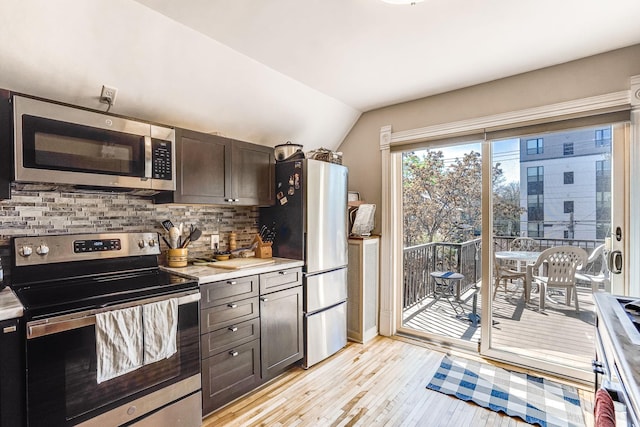 1976 Iglehart Ave, Saint Paul, MN 55104 - kitchen with appliances with stainless steel finishes, light wood-style floors, lofted ceiling, tasteful backsplash, and light countertops