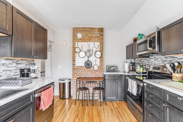 1976 Iglehart Ave, Saint Paul, MN 55104 - kitchen with appliances with stainless steel finishes, light countertops, backsplash, and light wood-style flooring