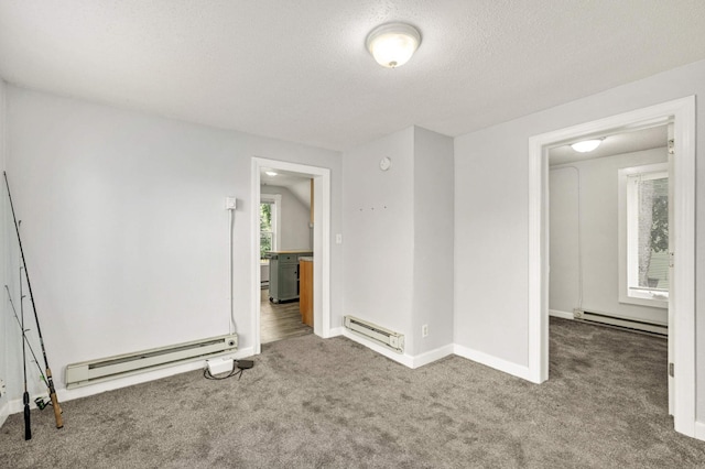 carpeted spare room featuring a textured ceiling, a baseboard heating unit, and baseboards