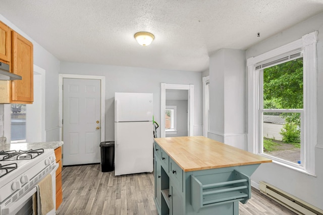 kitchen with light wood-type flooring, white appliances, butcher block counters, and a baseboard radiator