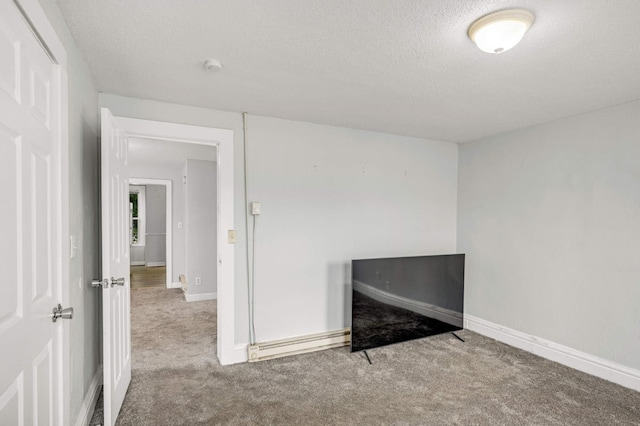 empty room featuring baseboards, a textured ceiling, carpet flooring, and a baseboard radiator