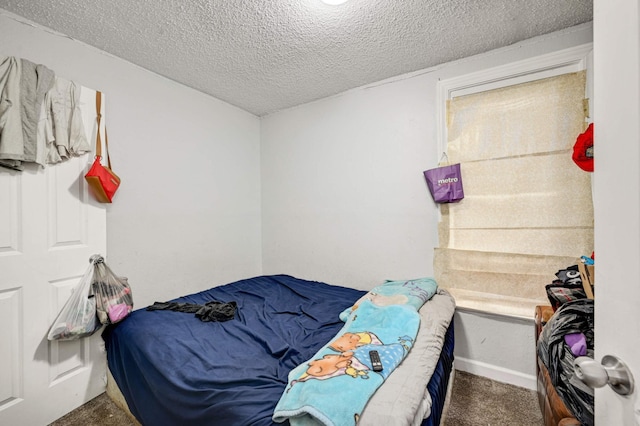 carpeted bedroom featuring baseboards and a textured ceiling