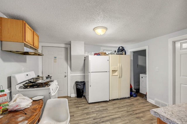 kitchen featuring visible vents, white appliances, light wood finished floors, and under cabinet range hood