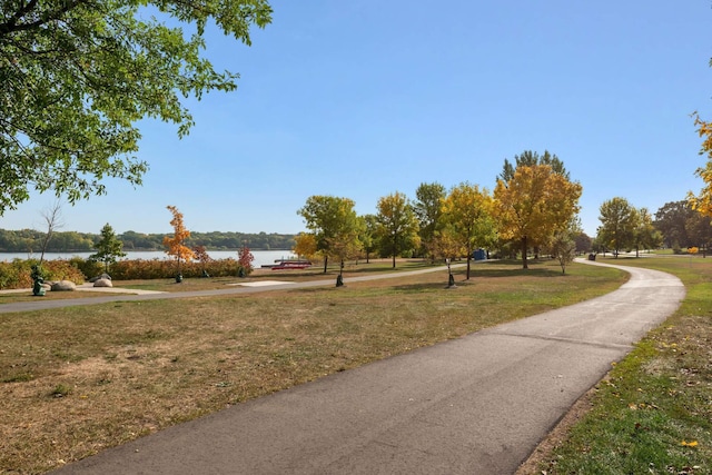 view of property's community with a lawn and a water view