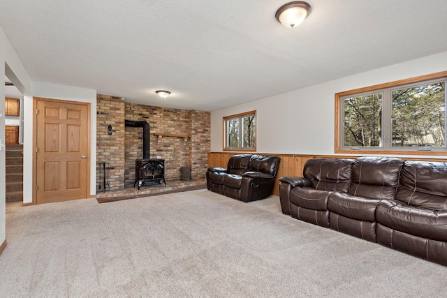 16881 169th Ave SE, Big Lake, MN 55309 - carpeted living area with a wood stove, a wainscoted wall, wooden walls, and a textured ceiling