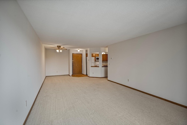 unfurnished living room with ceiling fan, light carpet, and baseboards