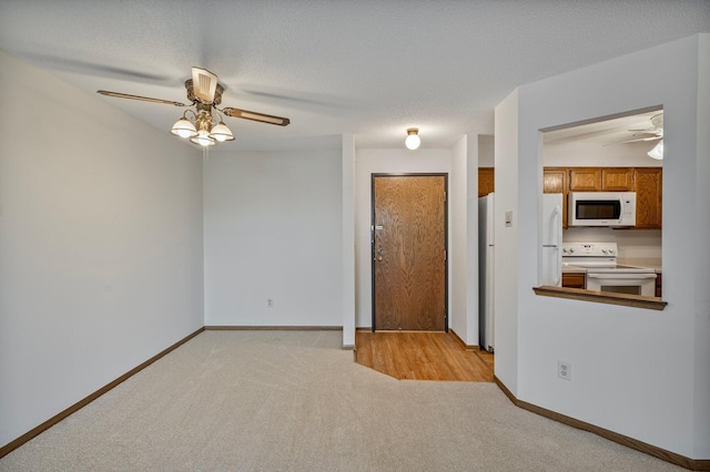 unfurnished room with carpet flooring, ceiling fan, and baseboards