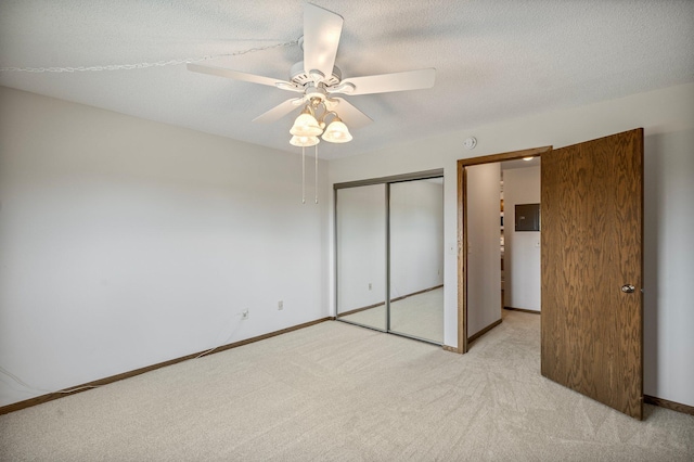 unfurnished bedroom with a closet, baseboards, a ceiling fan, and light carpet