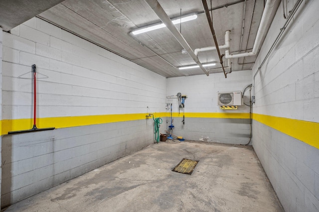 garage with concrete block wall and ac unit