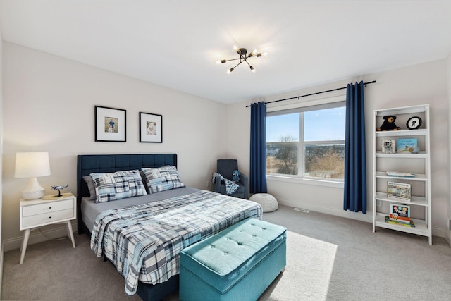 bedroom with baseboards, an inviting chandelier, and carpet