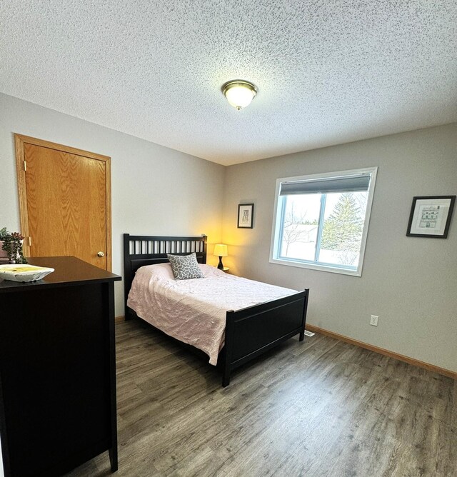 606 Tenth St W, Park Rapids, MN 56470 - bedroom with wood finished floors, a textured ceiling, and baseboards