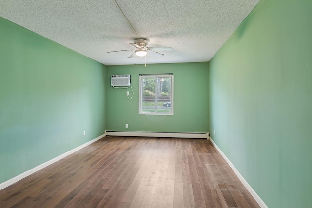 spare room featuring ceiling fan, a textured ceiling, wood finished floors, a baseboard radiator, and an AC wall unit