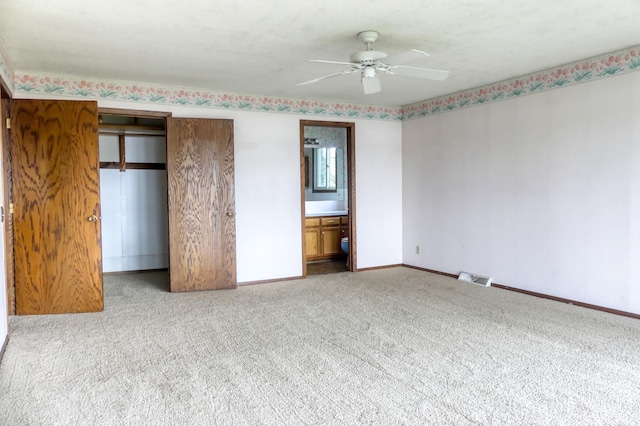 12056 Everton Ave N, Hugo, MN 55110 - unfurnished bedroom with carpet floors, baseboards, ensuite bathroom, and a ceiling fan