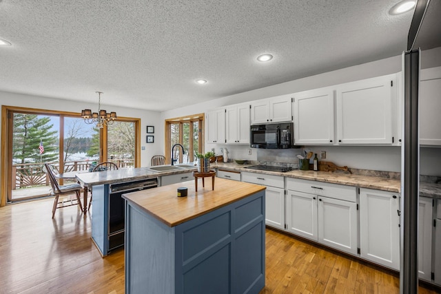 1171 County Rd E, Scott Twp, WI 54801 - kitchen with a sink, a textured ceiling, butcher block counters, and black appliances