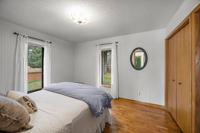 1171 County Rd E, Scott Twp, WI 54801 - bedroom featuring a textured ceiling, baseboards, and light wood finished floors