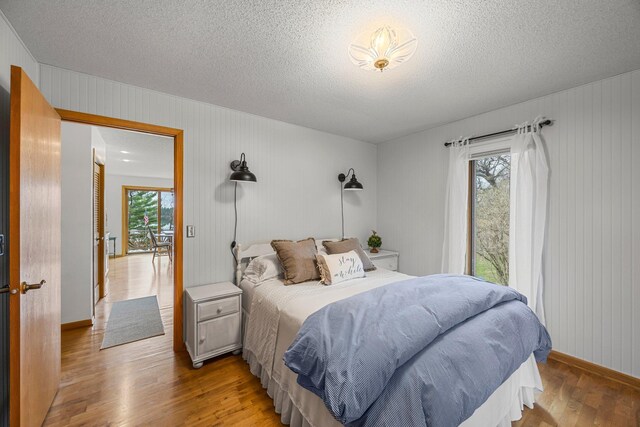 1171 County Rd E, Scott Twp, WI 54801 - bedroom with baseboards, a textured ceiling, and wood finished floors