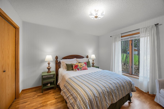 1171 County Rd E, Scott Twp, WI 54801 - bedroom featuring baseboards, a textured ceiling, wood finished floors, and a closet