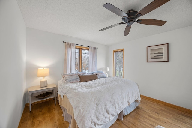 1171 County Rd E, Scott Twp, WI 54801 - bedroom featuring a textured ceiling, baseboards, ceiling fan, and light wood-style floors