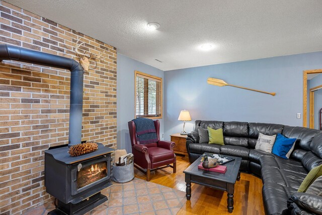 1171 County Rd E, Scott Twp, WI 54801 - living area featuring a textured ceiling, wood finished floors, a wood stove, and brick wall