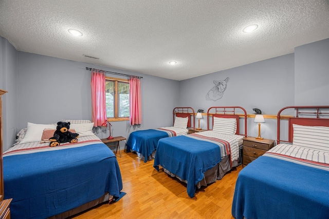 1171 County Rd E, Scott Twp, WI 54801 - bedroom with visible vents, a textured ceiling, and wood finished floors