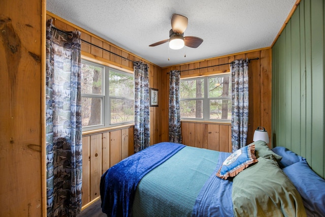 1171 County Rd E, Scott Twp, WI 54801 - bedroom with wood walls, a textured ceiling, and a ceiling fan