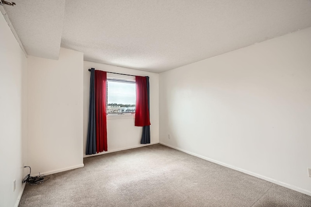unfurnished room with baseboards, carpet flooring, and a textured ceiling