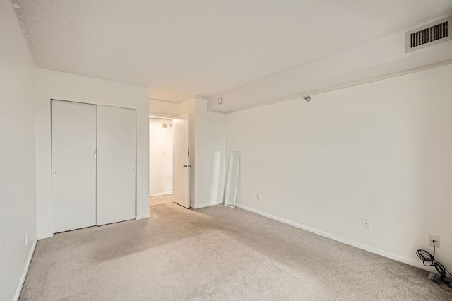 unfurnished bedroom with visible vents, baseboards, and light carpet