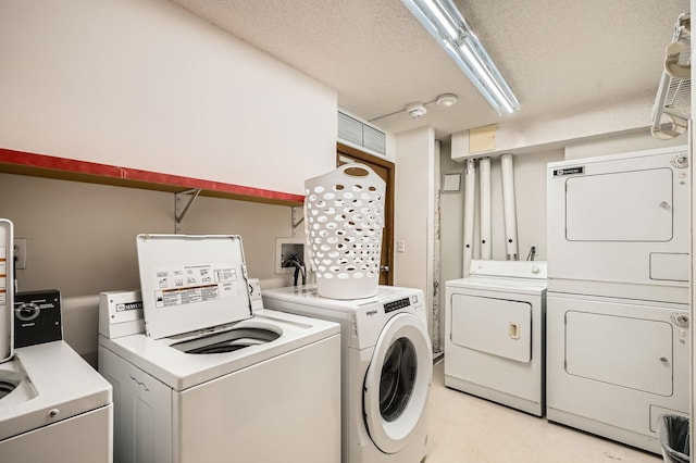 laundry room featuring separate washer and dryer and a textured ceiling
