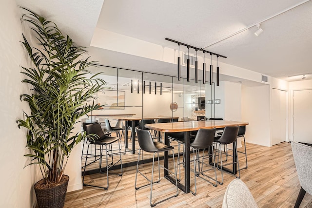 dining area with visible vents, track lighting, and wood finished floors