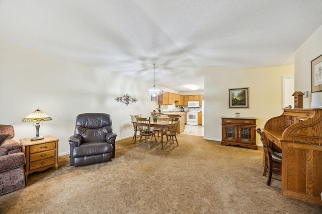 living area featuring lofted ceiling, light colored carpet, baseboards, and a textured ceiling