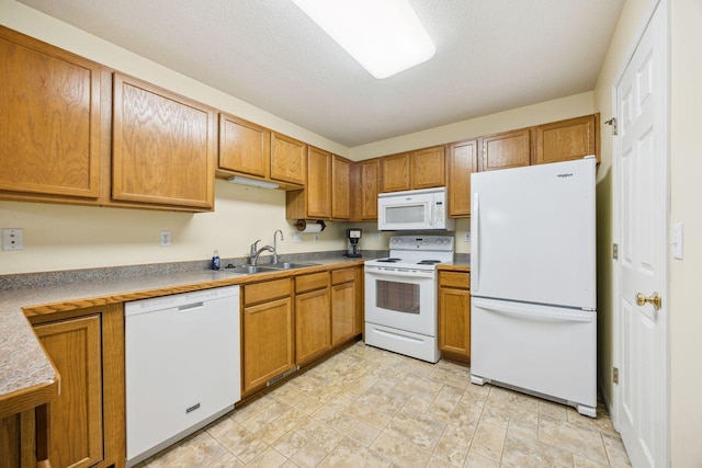 kitchen with white appliances, a sink, and brown cabinetry