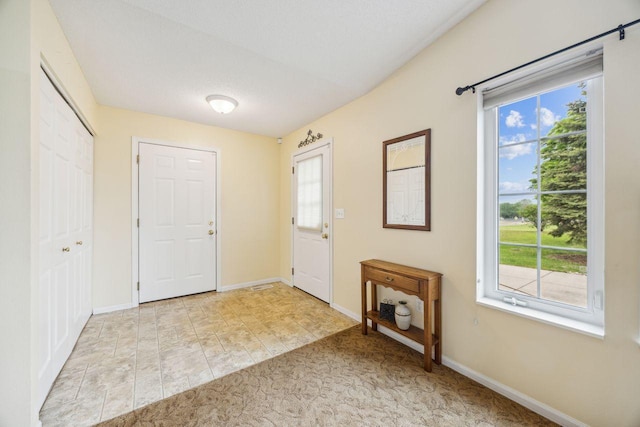 carpeted entryway featuring baseboards