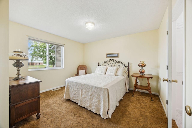 carpeted bedroom featuring baseboards and a textured ceiling