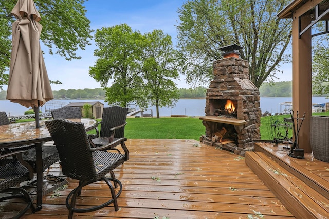 2060 Donnelly Dr NW, Maple Lake Twp, MN 55313 - wooden terrace with an outdoor stone fireplace, a water view, outdoor dining space, and a yard