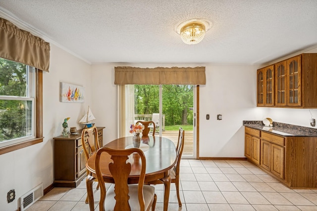 18701 Delton Ave, Minnetonka, MN 55345 - dining room with healthy amount of natural light, light tile patterned floors, a textured ceiling, a chandelier, and baseboards