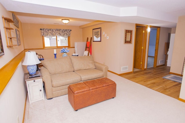living room with wood finished floors, visible vents, carpet flooring, and baseboards
