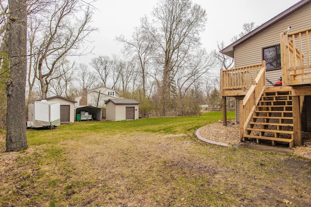 view of yard featuring stairway, an outbuilding, a detached carport, a deck, and a storage unit