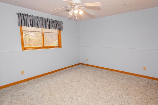 spare room featuring a ceiling fan, carpet floors, and baseboards