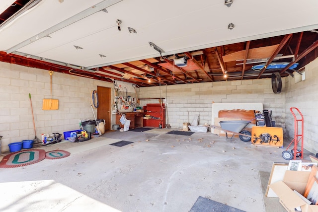 garage with concrete block wall and a garage door opener