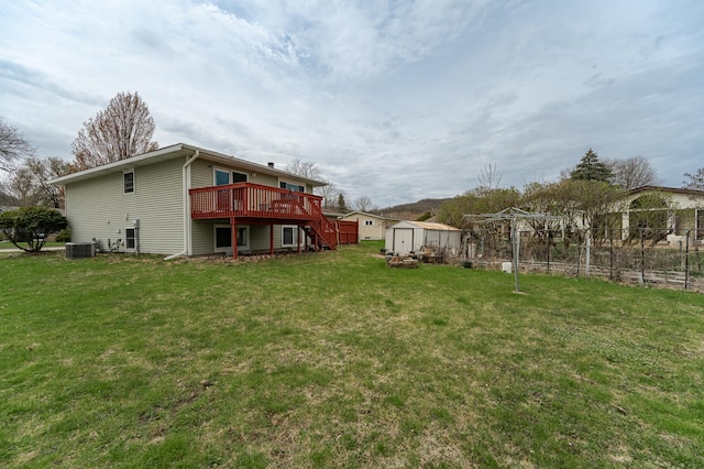 view of yard with a storage shed, a wooden deck, stairway, an outbuilding, and central AC unit