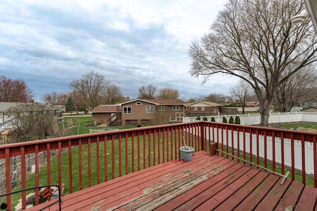 deck featuring a fenced backyard, a yard, and a residential view
