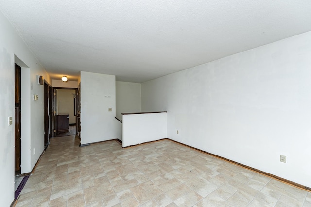 unfurnished room with baseboards and stone finish flooring
