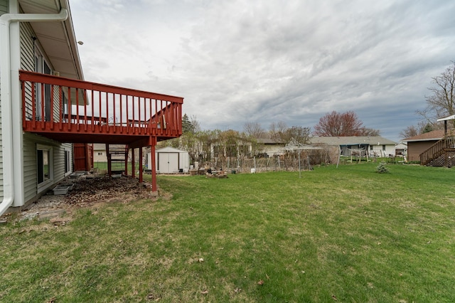 view of yard featuring stairway, a wooden deck, an outbuilding, and a storage unit
