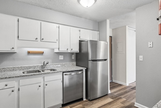 221 Grand Ave W Unit 111, South Saint Paul, MN 55075 - kitchen with a textured ceiling, a sink, white cabinetry, wood finished floors, and stainless steel appliances