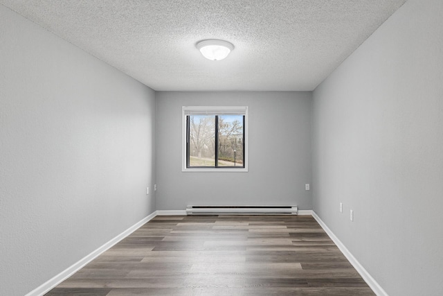 221 Grand Ave W Unit 111, South Saint Paul, MN 55075 - unfurnished room featuring baseboards, baseboard heating, a textured ceiling, and wood finished floors