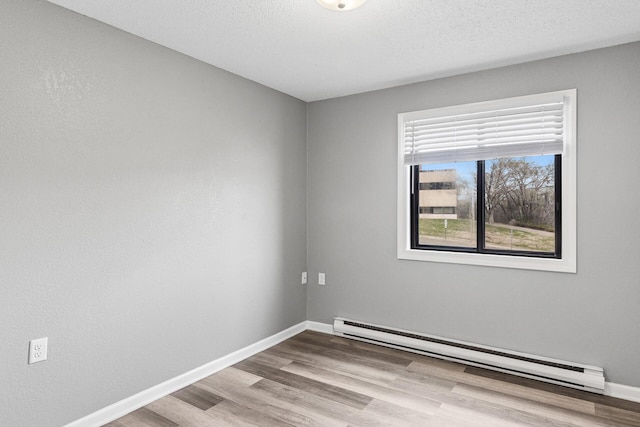221 Grand Ave W Unit 111, South Saint Paul, MN 55075 - unfurnished room featuring baseboard heating, wood finished floors, and baseboards