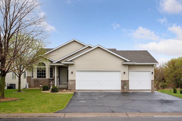 ranch-style home with a shingled roof, a front lawn, brick siding, a garage, and aphalt driveway