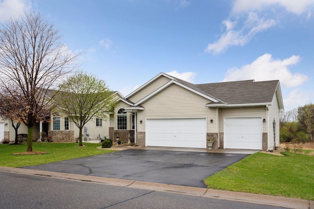 view of front of property with roof with shingles, a garage, brick siding, aphalt driveway, and a front lawn