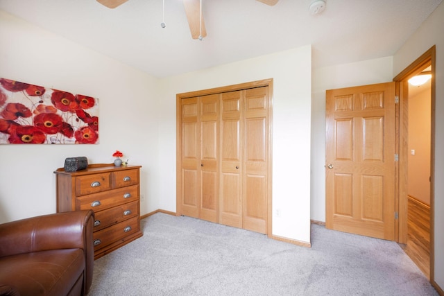 living area featuring baseboards, carpet flooring, and ceiling fan