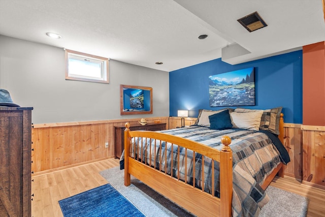 510 State Rd Unit 35, Centuria, WI 54024 - bedroom featuring recessed lighting, a wainscoted wall, wood walls, and wood finished floors
